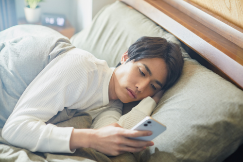 Stressed Man on Phone in Bed